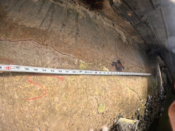 Measured horizontal crack across a concrete seawall face with field-survey markings