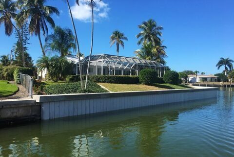 Completed Truline composite seawall protecting a luxury residential Florida property with screened pool enclosure
